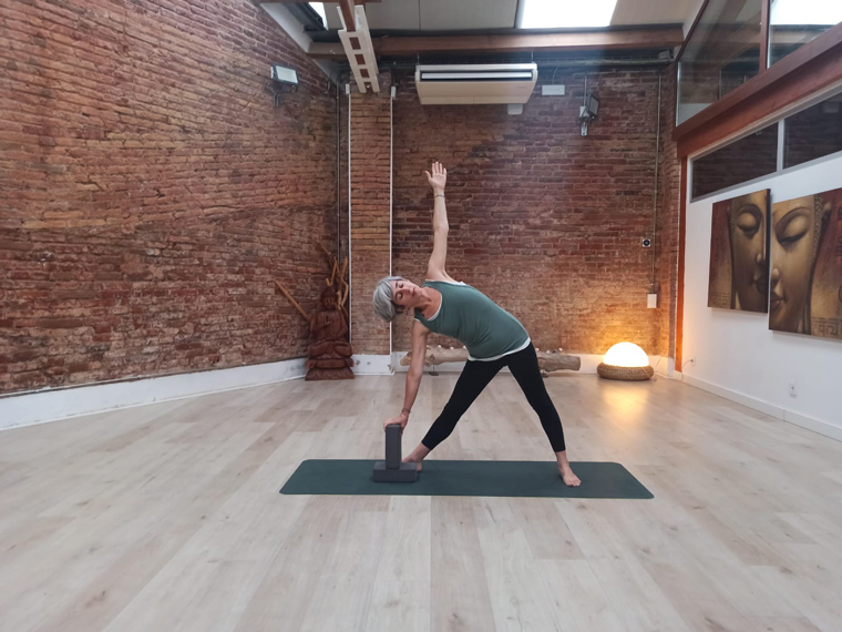Eva Moure, profesora de Yoga Oncológico, en la postura del triángulo, utilizando un bloque como soporte